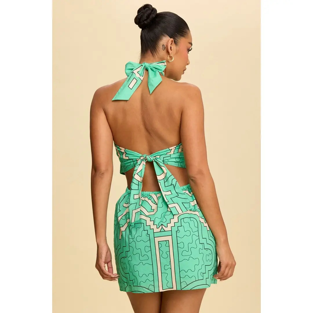 Woman wearing a green patterned dress with a bow