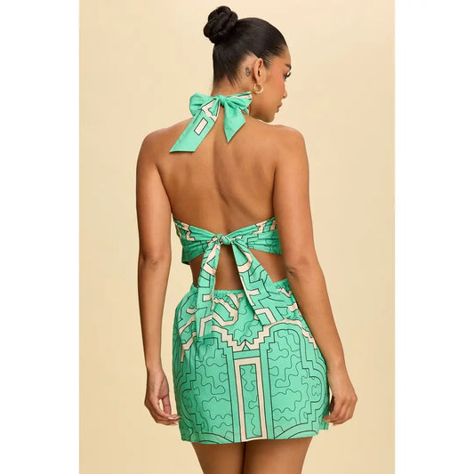 Woman wearing a green patterned dress with a bow